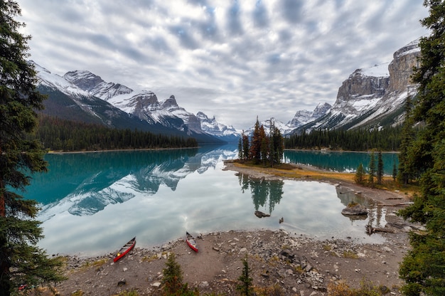 Canoa anclada con reflejo rocoso canadiense en el lago Maligne en la isla Spirit en el parque nacional Jasper