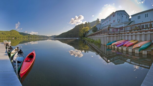 Foto una canoa roja está amarrada al borde de un lago.