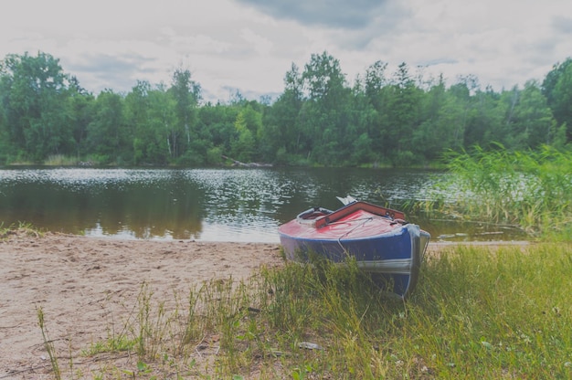 Canoa solitaria en la orilla de un lago forestal en un día de verano.