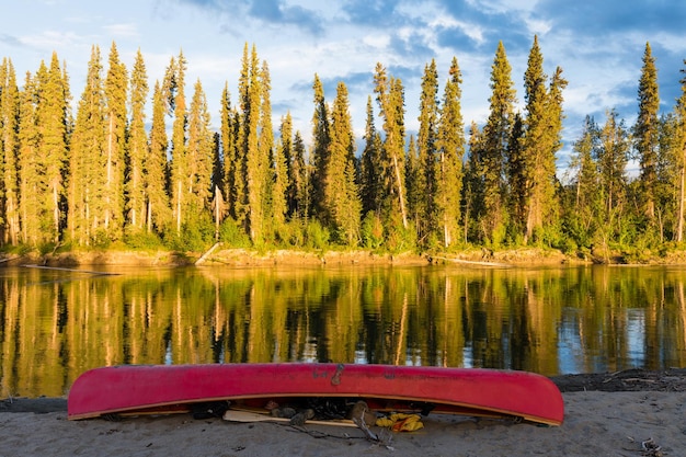 Canoa vermelha na costa do Rio Nisutlin Yukon Canadá