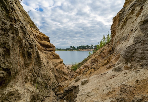 Un cañón de arena a la orilla de un lago en las montañas