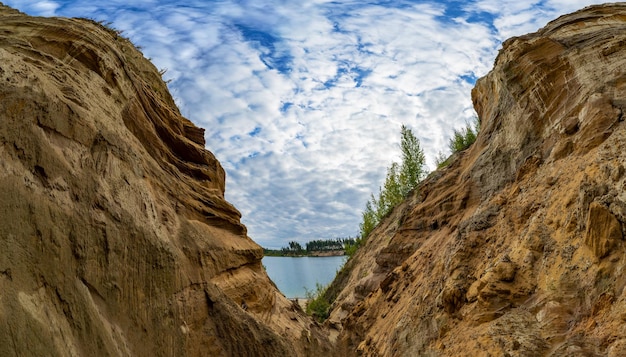 Un cañón de arena a la orilla de un lago en las montañas