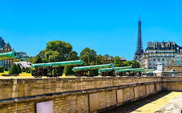 Cañones históricos en les invalides con torre eiffel en parís francia