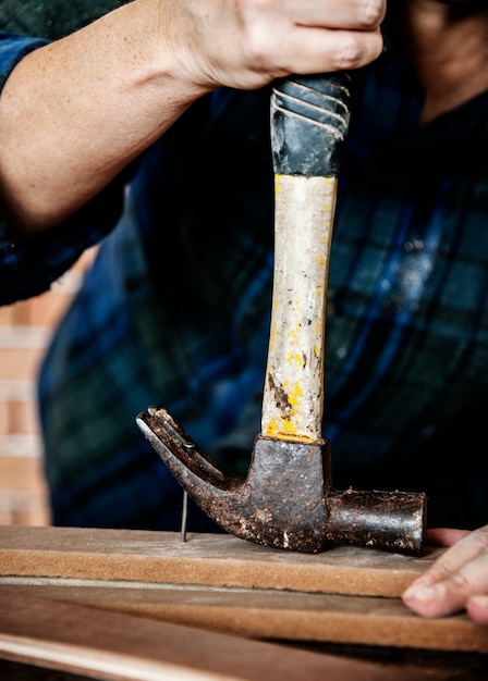 Canpenter, der Hammer verwendet, ziehen einen Nagel aus einem Holz heraus