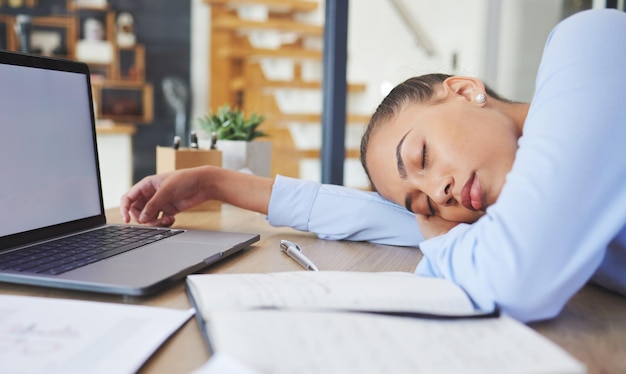 Cansada, exausta e mulher de negócios dormindo em sua mesa enquanto trabalhava em um escritório moderno Burnout sonolenta e funcionária corporativa profissional tirando uma soneca enquanto planejava um projeto em seu local de trabalho