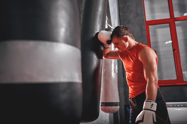 Cansado após o treino, cansou o jovem atleta em roupas esportivas, olhando para longe após um treino intenso em