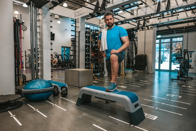 Cansado después del entrenamiento. Hombre con toalla en el gimnasio después del entrenamiento