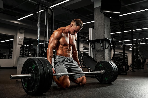 Cansado dos treinos diários, o fisiculturista reúne seu ânimo antes do exercício com barra, motivação esportiva, superação de si mesmo.