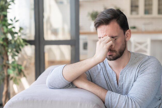 Cansado, estressado, triste, entediado, jovem caucasiano a relaxar depois do trabalho, problemas de relacionamento familiar.