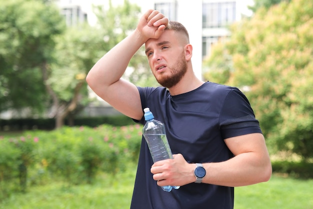 Cansado hombre agotado joven atlético en forma se siente mal malestar después de correr trotar al aire libre con disnea mareos que sufren de dolor tipo de calor con insolación Tener insolación en verano