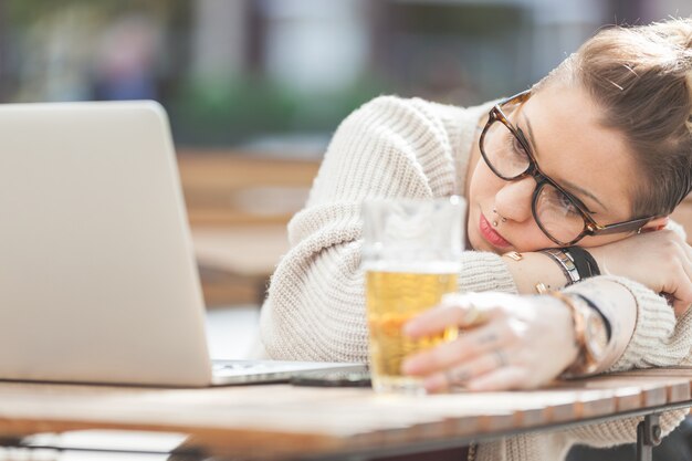 Cansado menina com cerveja e computador em Londres