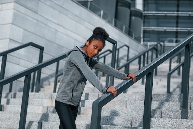 Cansado toma descanso Joven mujer afroamericana en ropa deportiva hacer ejercicio al aire libre durante el día