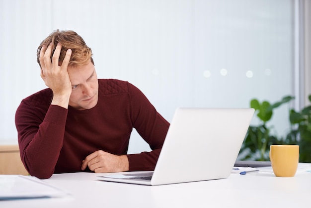 Cansado del trabajo Un apuesto hombre de negocios trabajando en su escritorio