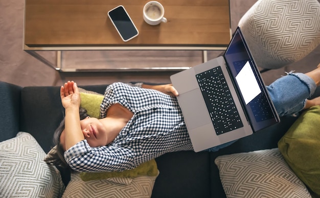 Cansado del trabajo mujer joven frente a una computadora portátil