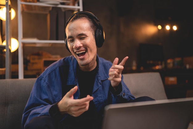 Cantante con auriculares trabajando para grabar y tocar una voz musical con un micrófono profesional en un estudio de audio. El vocalista canta una canción con un músico e ingeniero de sonido con transmisión en vivo.