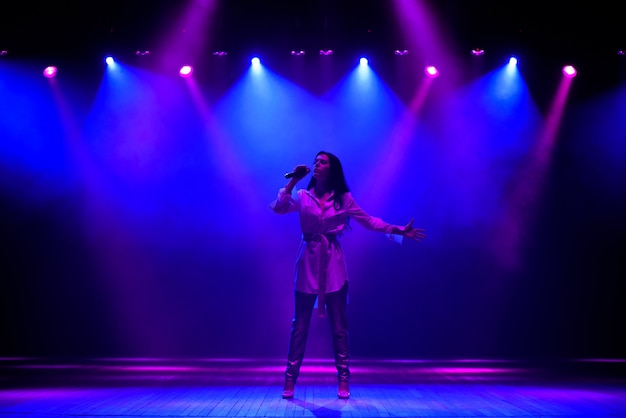 Cantante estrella actuando en solitario en escena en el music hall con luces de neón