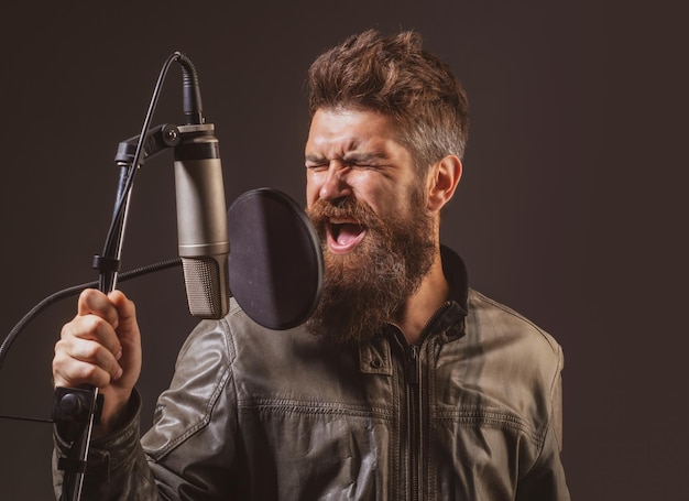 Cantante expresivo con micrófono Hombre guapo en estudio de grabación Cantante vocal de interpretación musical si