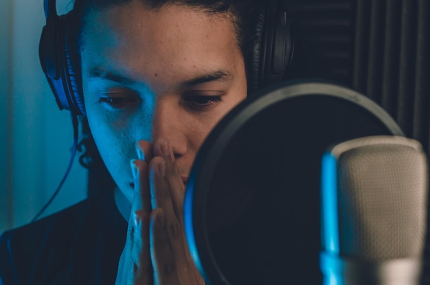 Cantante masculino profesional en grabación de estudio escuchando atentamente el audio grabado