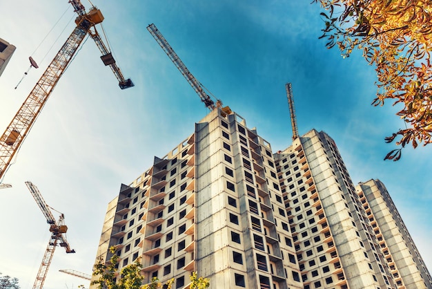 Canteiro de obras com edifícios e guindastes industriais