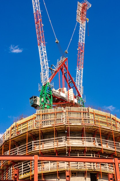 Canteiro de obras com guindastes com céu azul