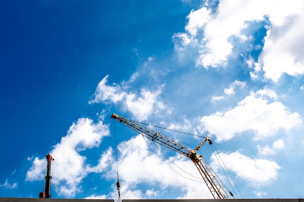 Canteiro de obras com guindastes no céu azul