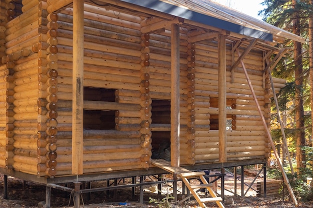 Canteiro de obras da casa de montanha de madeira tradicional cabana construída a partir de toras de madeira em dia ensolarado