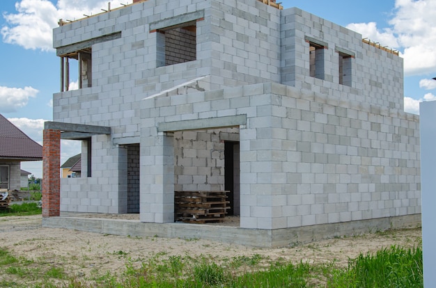 Foto canteiro de obras de uma casa em construção feita de blocos de concreto de espuma branca. construindo uma nova estrutura de casa.