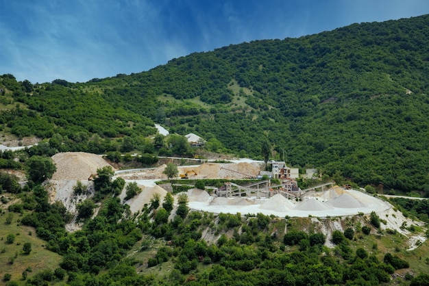 Cantera para la extracción de minerales con equipos y máquinas y carreteras en las Montañas Ródope cubiertas de bosques