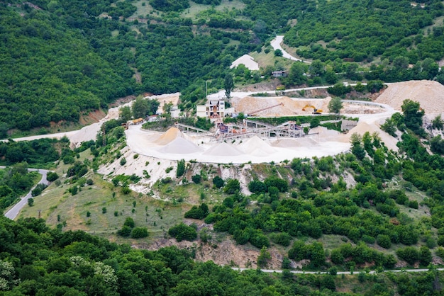 Cantera para la extracción de minerales con equipos y máquinas y carreteras en las Montañas Ródope cubiertas de bosques