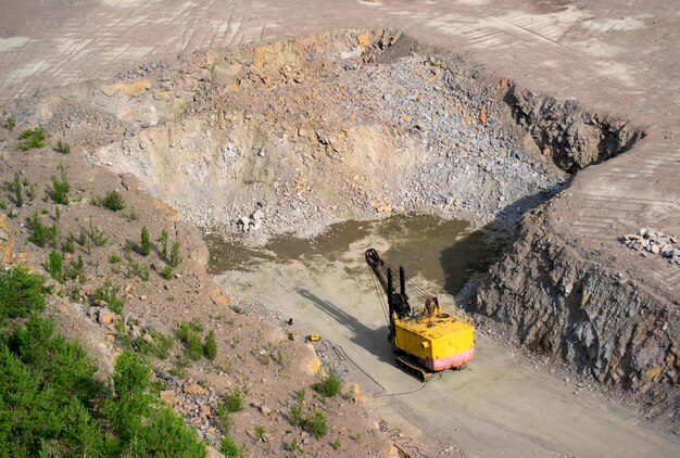 Cantero excavadora amarilla en una cantera de granito