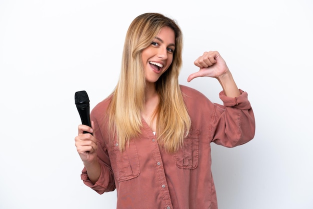 Cantora uruguaia pegando um microfone isolado em fundo branco orgulhoso e satisfeito