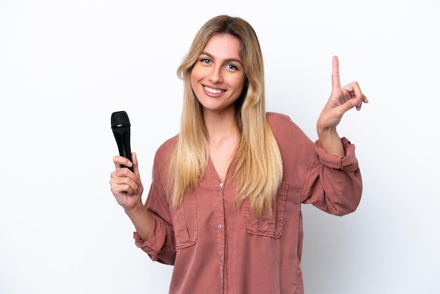 Cantora uruguaia pegando um microfone isolado no fundo branco apontando uma ótima ideia