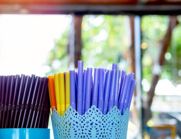 Canudos de plástico coloridos em recipiente de plástico na cafeteria