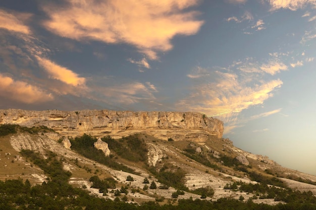 Canyon de montanha na estação seca contra o pano de fundo do pôr do sol e nuvens rosa White Rock Crimea