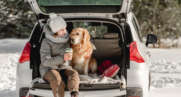 Cão retriever dourado com garota no inverno