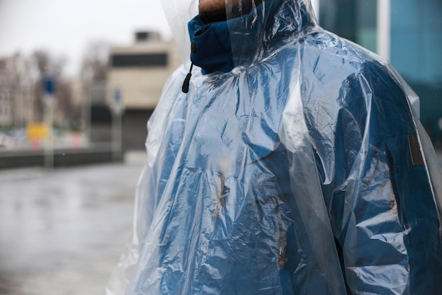 Capa de chuva em um homem atirando lá fora