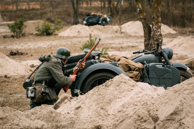 Capa do lacaio da Wehrmacht atrás de uma motocicleta