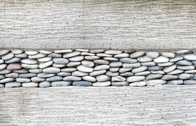 Capa de la pared con guijarros piedra y cemento, fondo de textura