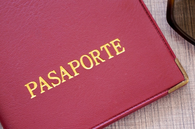Capa vermelha para passaporte com letras douradas em idioma espanhol