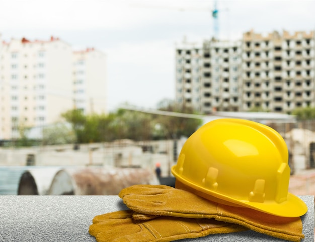 Capacete amarelo com equipamento no fundo