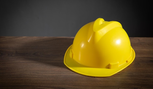 Capacete de construção amarelo na mesa de madeira