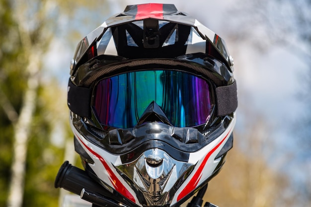 Foto capacete de motocicleta com máscara na sela com um fundo bonito