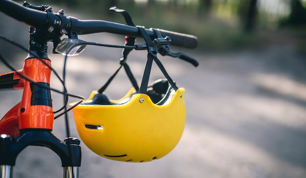 Capacete de proteção pendurado no guidão de bicicleta, close-up