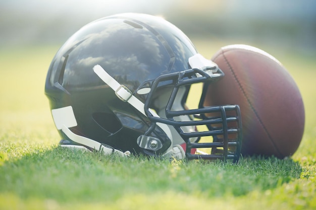 Capacete de rugby com bola no campo