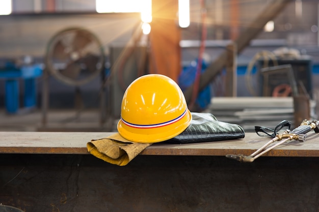 Capacete de segurança amarelo e luvas de couro velhas