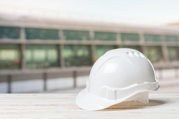 Capacete de segurança branco em madeira branca