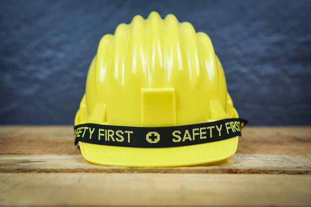 Capacete de trabalhador de engenheiro em fundo de madeira - segurança primeiro conceito amarelo capacete de segurança desgaste duro chapéu