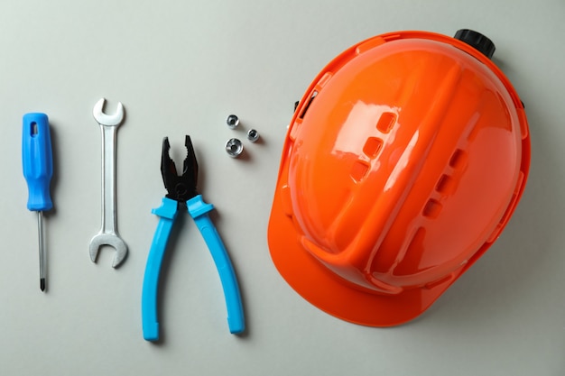 Capacete e ferramentas de trabalho em cinza claro