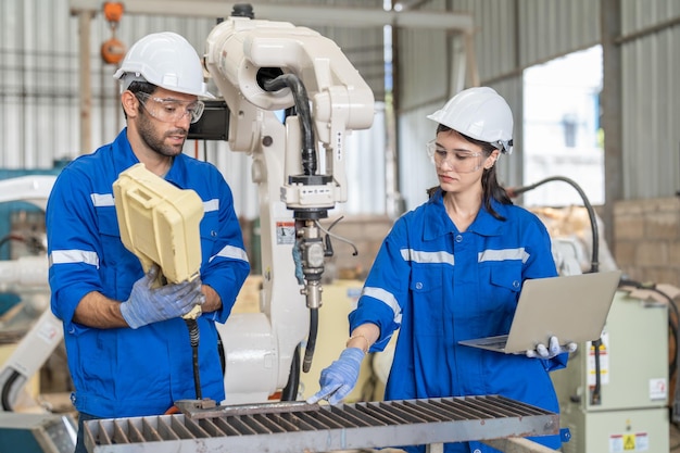 Capacitación de ingenieros masculinos y femeninos utilizando una máquina de soldadura de brazo robótico de control remoto en fábrica
