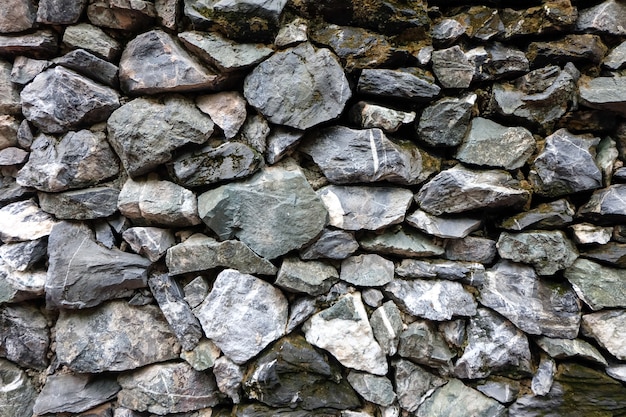 Las capas apiladas fondo real de la textura de la pared de piedra son desiguales